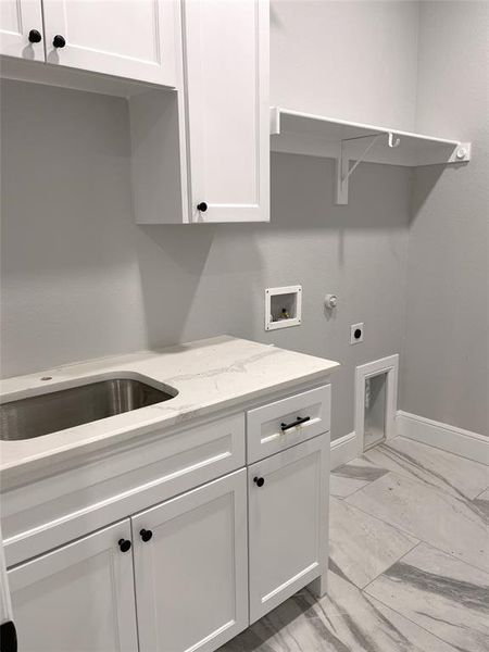 Laundry room featuring cabinets, hookup for a washing machine, sink, and electric dryer hookup