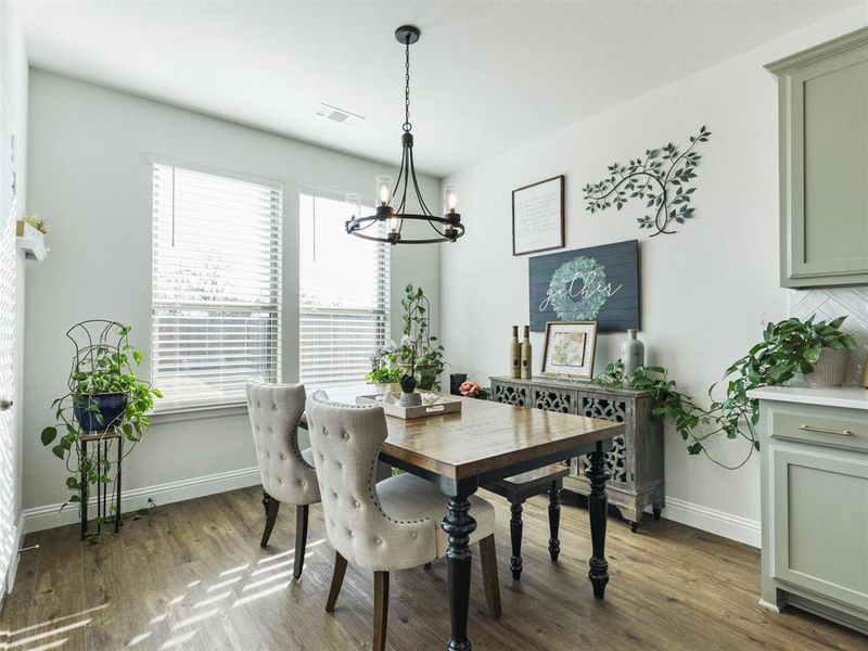 Dining area featuring dark wood-type flooring and a notable chandelier