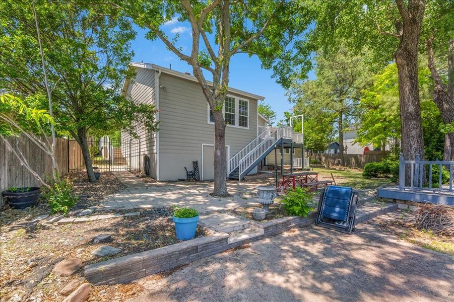 Back of house with a fenced backyard, a patio, and a wooden deck