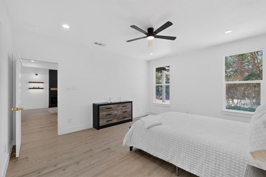 Bright room featuring wood-finish flooring, recessed lighting, and a contemporary ceiling fan