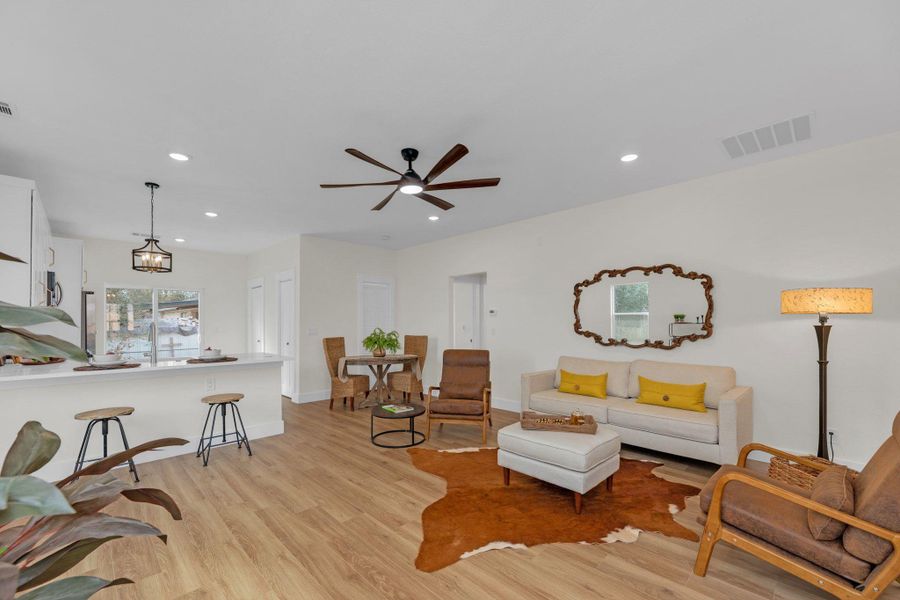 ADU living area with ceiling fans open to full kitchen.