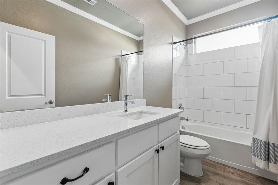 White vanity with a light-toned countertop, under-mount sink, and chrome faucet