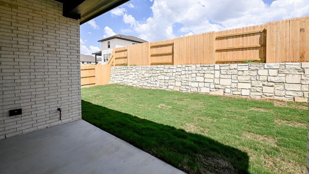 Fenced backyard with a patio area Fenced backyard with a patio area