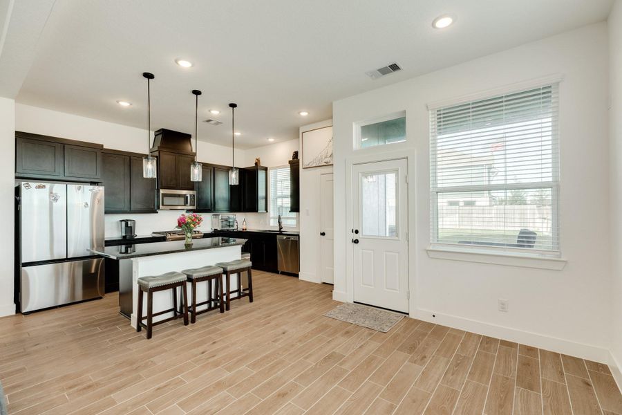this view is of the dining area on the right , the back door and kitchen area on the left
