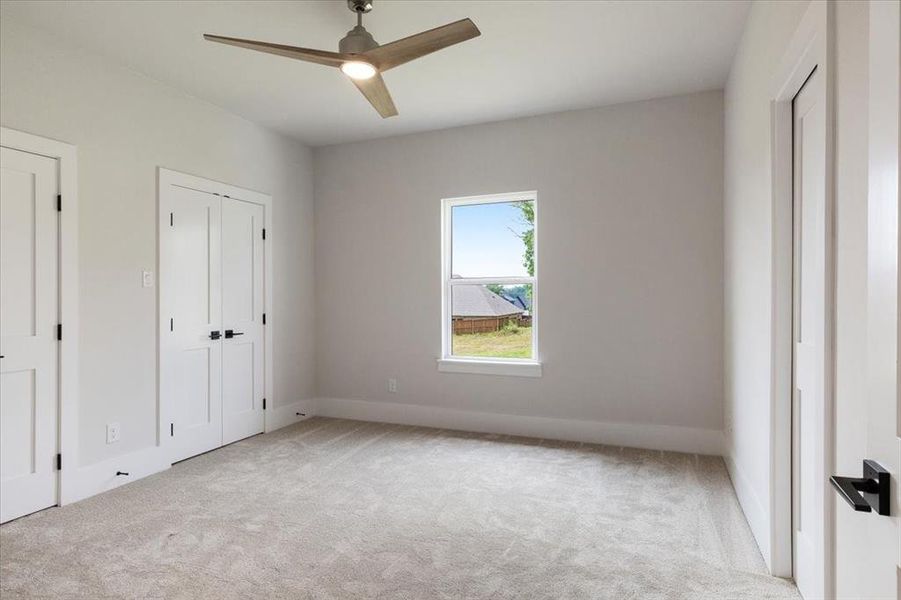 Carpeted spare room with ceiling fan