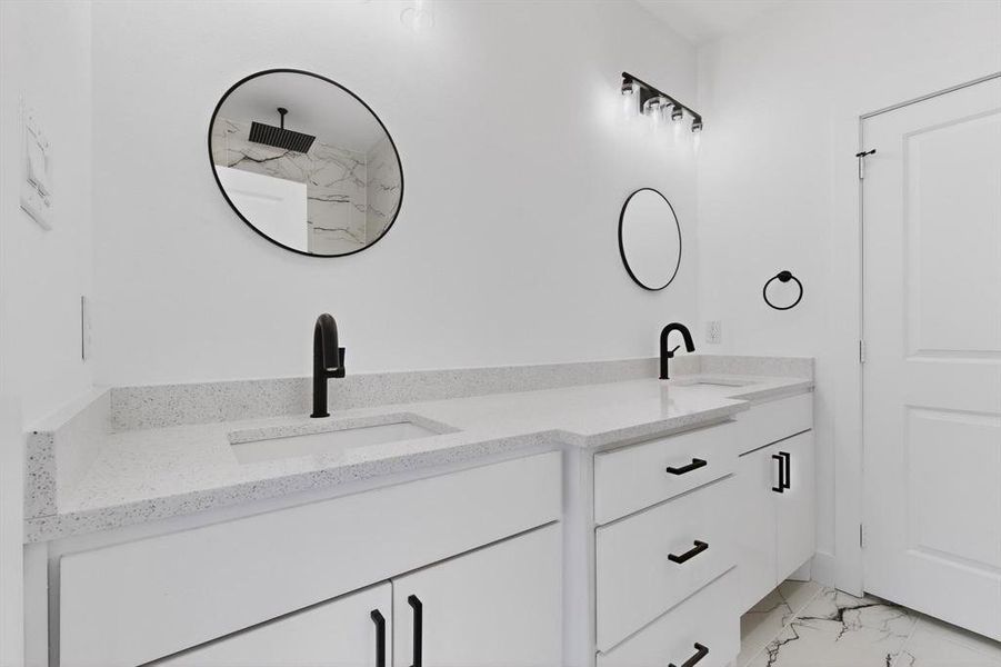 Full bathroom featuring light marble finish flooring and double vanity