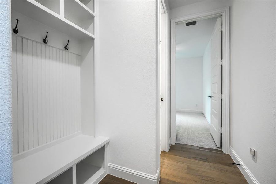 Mudroom featuring visible vents, baseboards, and dark wood-style flooring