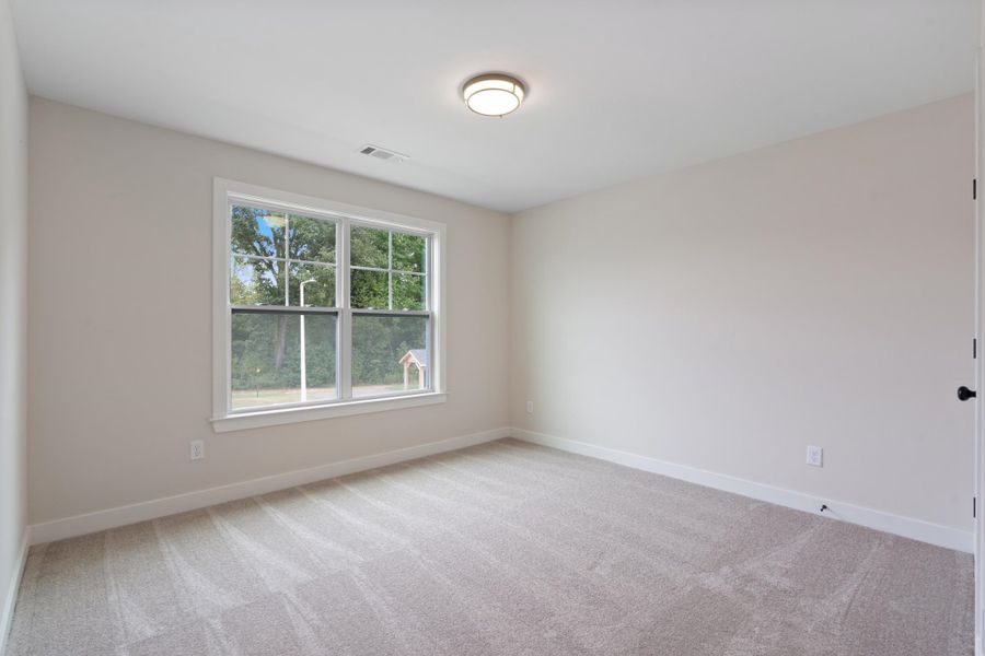 Neutral wall color, wall-to-wall carpeting, recessed ceiling light, white trim, and a window with a white frame Neutral wall color, wall-to-wall carpeting, recessed ceiling light, white trim, and a window with a white frame