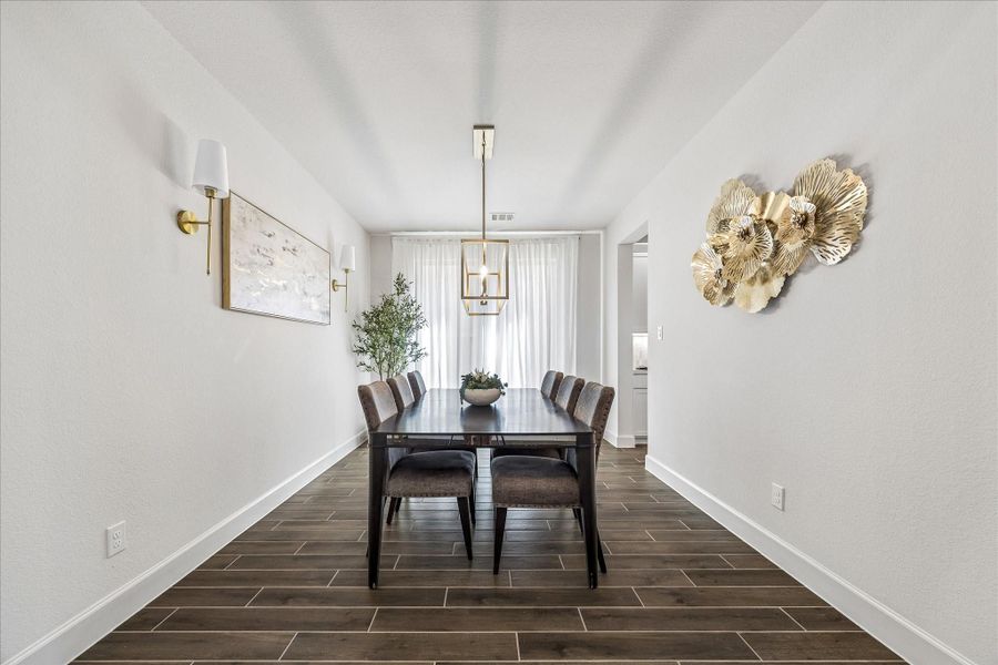 Elegant formal dining room with designer lighting and access to butler's pantry