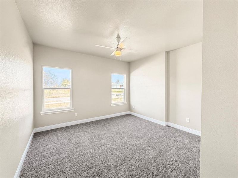Spare room with ceiling fan, a textured wall, carpet, and a textured ceiling