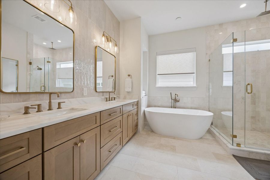 Primary bathroom, marble countertops, natural stone tile.