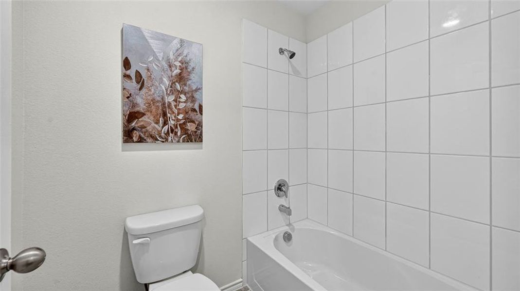 White ceramic tile shower surround with chrome fixtures and a classic white bathtub White ceramic tile shower surround with chrome fixtures and a classic white bathtub