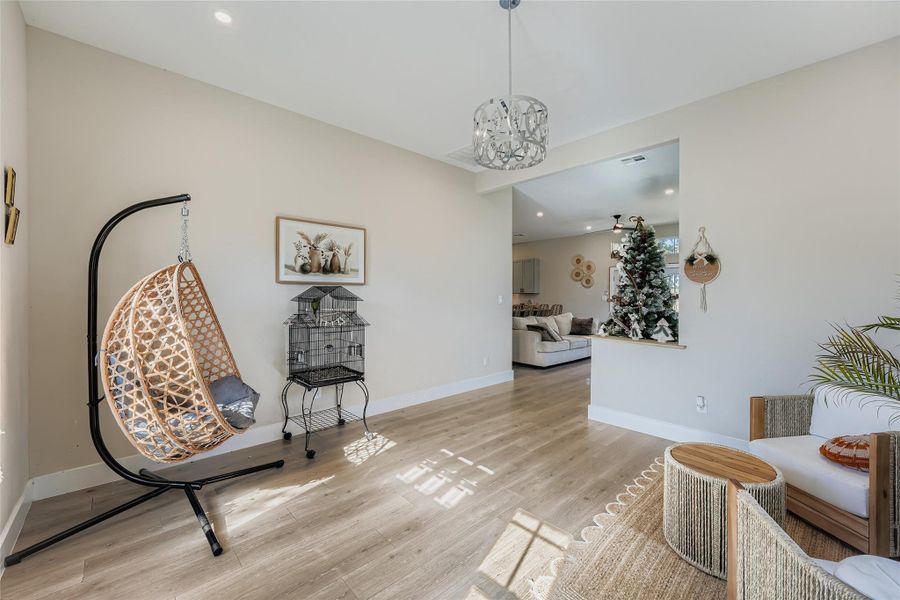Living area with recessed lighting, a chandelier, and light wood-type flooring Living area with recessed lighting, a chandelier, and light wood-type flooring