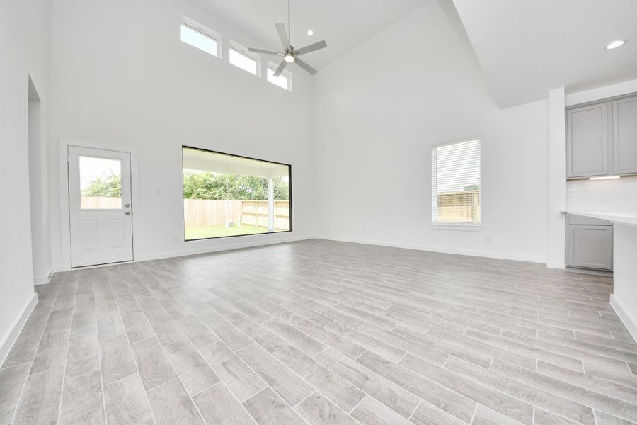 Gather the family and guests together in your lovely living room! Featuring soaring high ceilings, recessed lighting, ceiling fan, custom paint, gorgeous floors, and large windows that provide plenty of natural lighting throughout the day. Gather the family and guests together in your lovely living room! Featuring soaring high ceilings, recessed lighting, ceiling fan, custom paint, gorgeous floors, and large windows that provide plenty of natural lighting throughout the day.