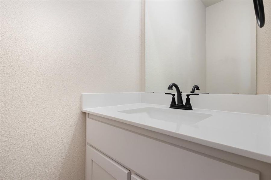 Bathroom with vanity and a textured wall