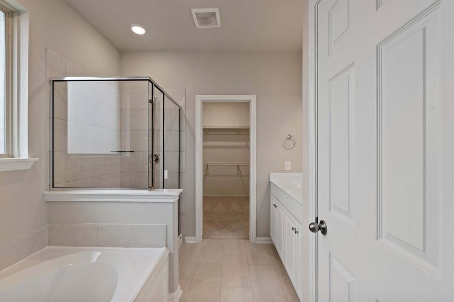 The en-suite bathroom offers a spa-like atmosphere with its elegant design, high end finishes, and tasteful lighting, creating a retreat within your own home.