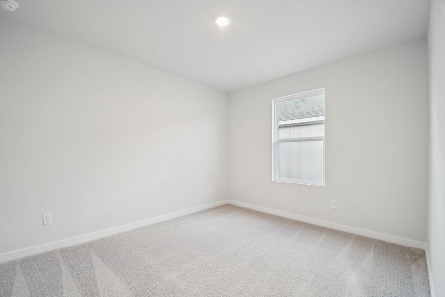 A room with a window and a carpet.