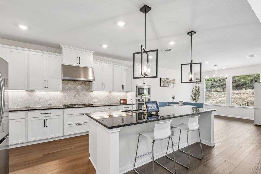 A contemporary kitchen features an open floorplan, showcasing stainless steel appliances and an inviting kitchen island.