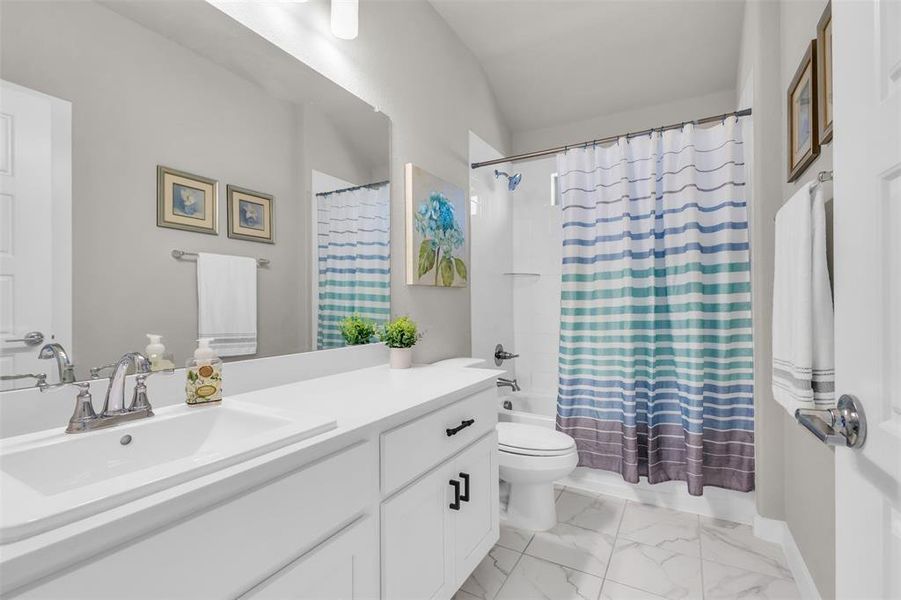 Full bathroom with shower / bath combination with curtain, vanity, and toilet