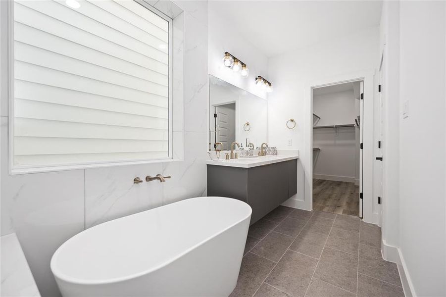 The oversized window brings in natural light into the bathroom.