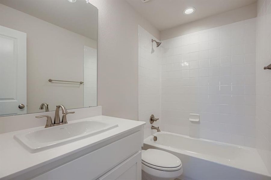 Bathroom with shower / washtub combination, vanity, and recessed lighting