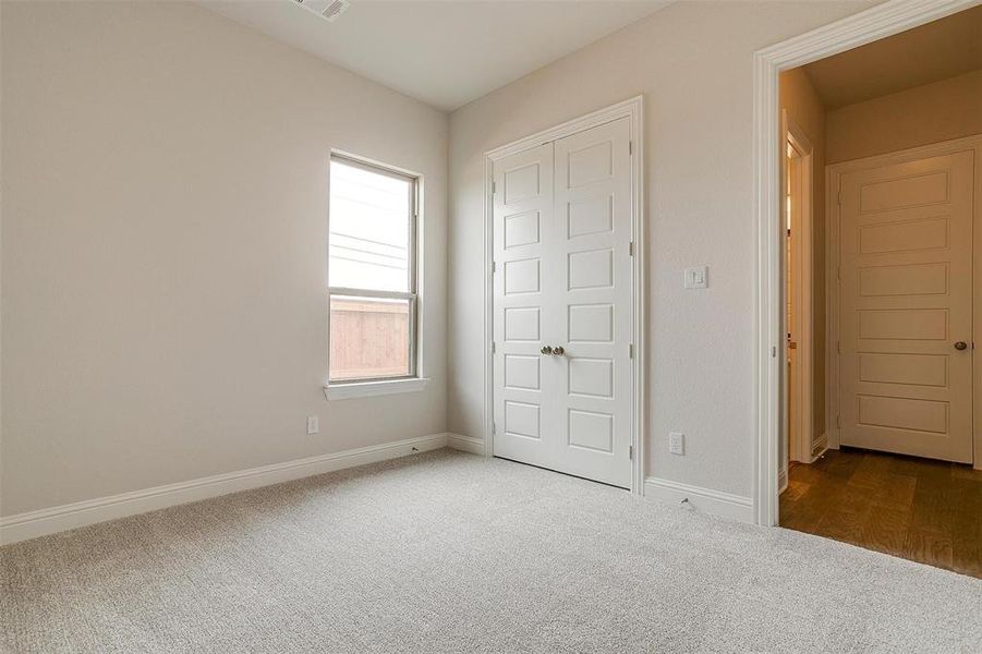 Unfurnished bedroom featuring dark carpet and a closet