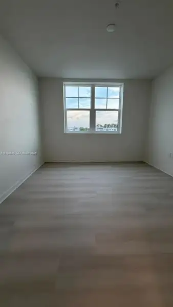 Neutral-toned wood-finish flooring and double-hung window with muntin detailing