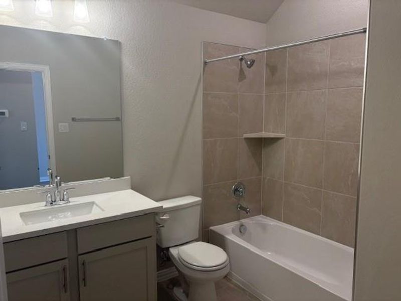Bathroom featuring a textured wall, shower / washtub combination, and vanity Bathroom featuring a textured wall, shower / washtub combination, and vanity