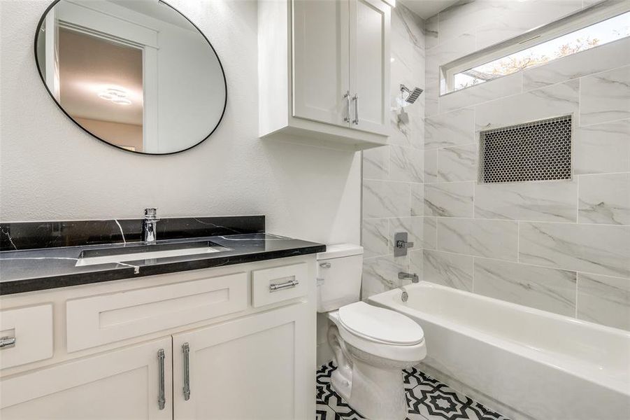 Full bathroom featuring vanity, toilet, and tiled shower / bath