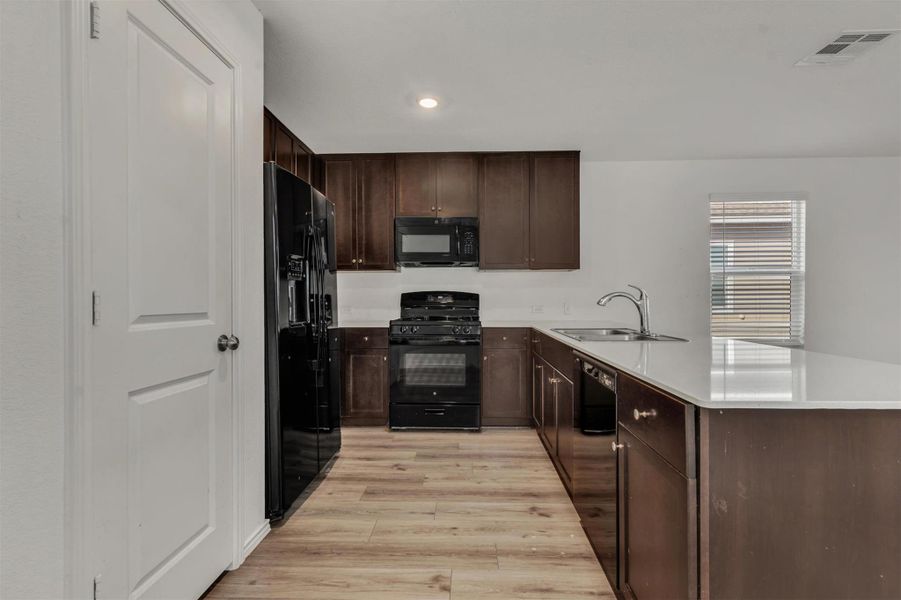 Rich cabinetry contrasts beautifully with clean countertops and durable flooring in this modern kitchen. Rich cabinetry contrasts beautifully with clean countertops and durable flooring in this modern kitchen.