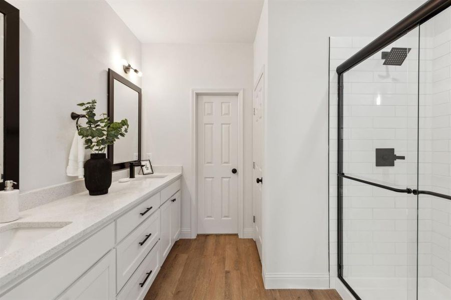 Bathroom with walk in shower, vanity, and hardwood / wood-style flooring