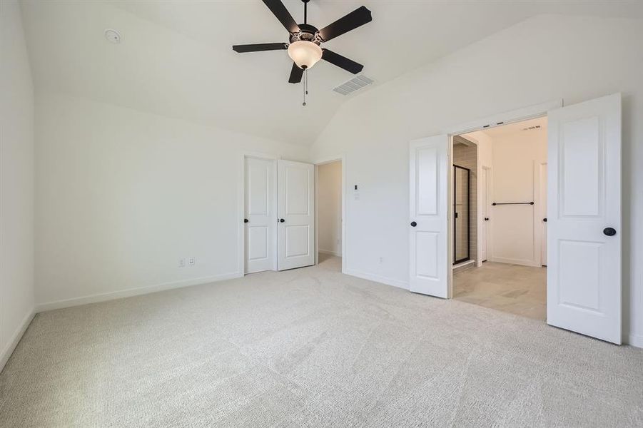 Unfurnished bedroom featuring lofted ceiling and light carpet Unfurnished bedroom featuring lofted ceiling and light carpet