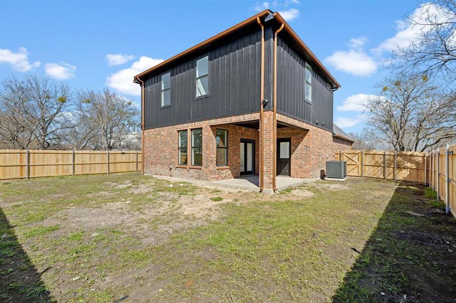 Rear view of property with a patio, a fenced backyard, cooling unit, a yard, and brick siding