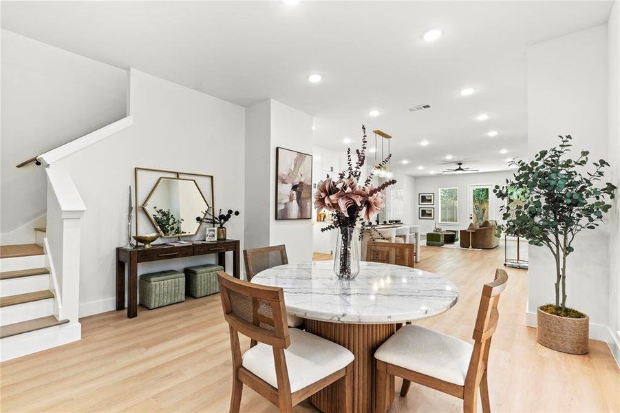Dining area with stairs, light wood-style floors, recessed lighting, and a ceiling fan Dining area with stairs, light wood-style floors, recessed lighting, and a ceiling fan