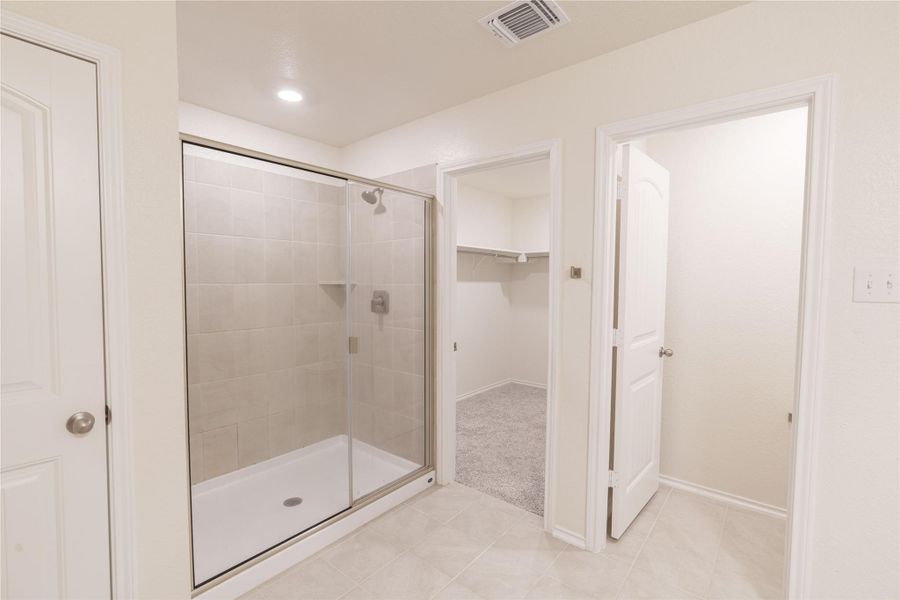 Tiled flooring and a glass-enclosed shower complement this pristine bathroom. Tiled flooring and a glass-enclosed shower complement this pristine bathroom.