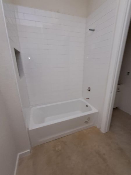 A well-appointed bathroom features a newly installed bathtub with crisp white subway tile surround.