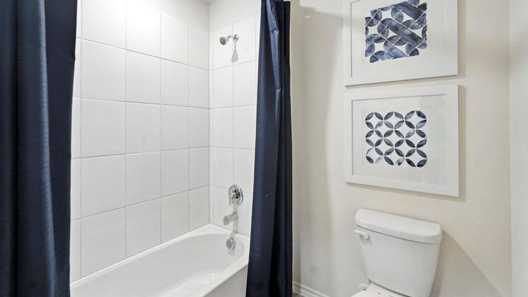 Bathroom featuring shower / bathtub combination with curtain and toilet Bathroom featuring shower / bathtub combination with curtain and toilet