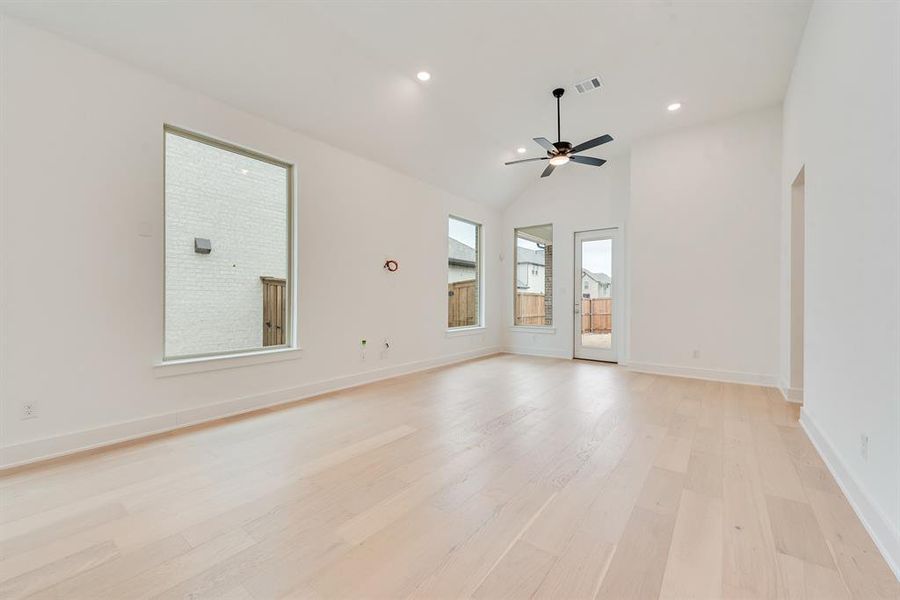 Spare room featuring light wood-style floors, recessed lighting, high vaulted ceiling, and ceiling fan Spare room featuring light wood-style floors, recessed lighting, high vaulted ceiling, and ceiling fan