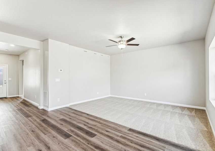 The family room is spacious and has a ceiling fan.