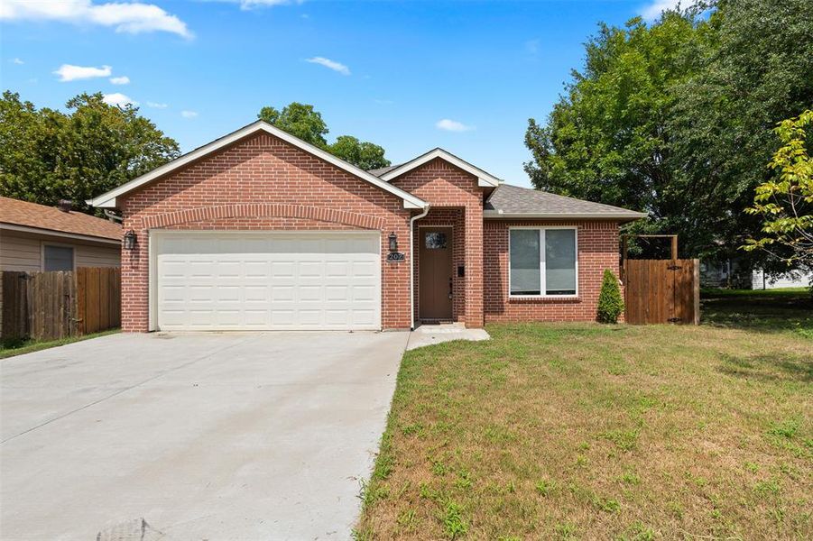 Ranch-style house featuring concrete driveway, brick siding, and a garage