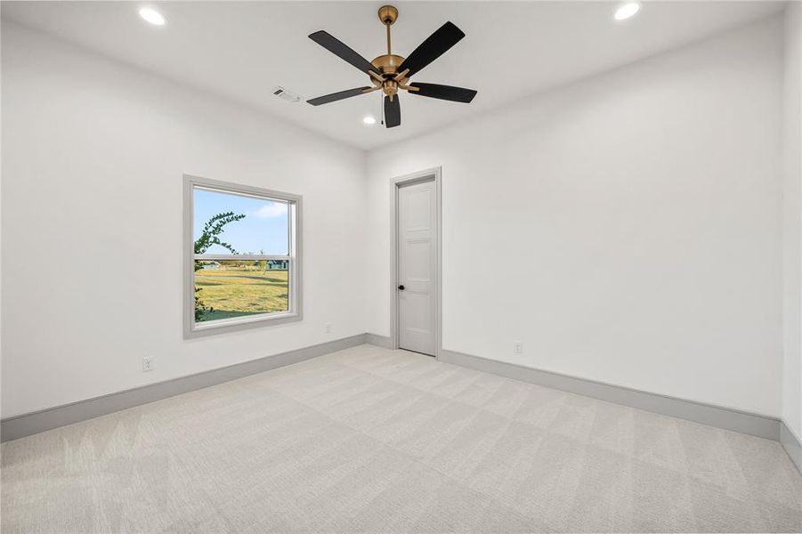 Empty room with light carpet, recessed lighting, and a ceiling fan Empty room with light carpet, recessed lighting, and a ceiling fan