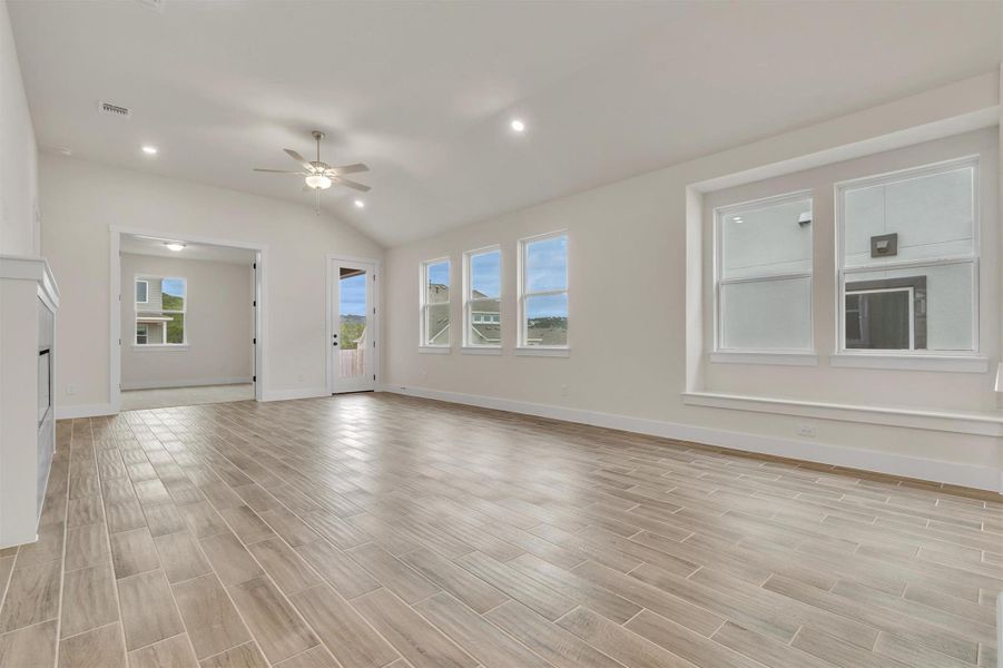 A spacious living area with vaulted ceilings and wide-plank tile flooring, providing an airy and contemporary feel.
