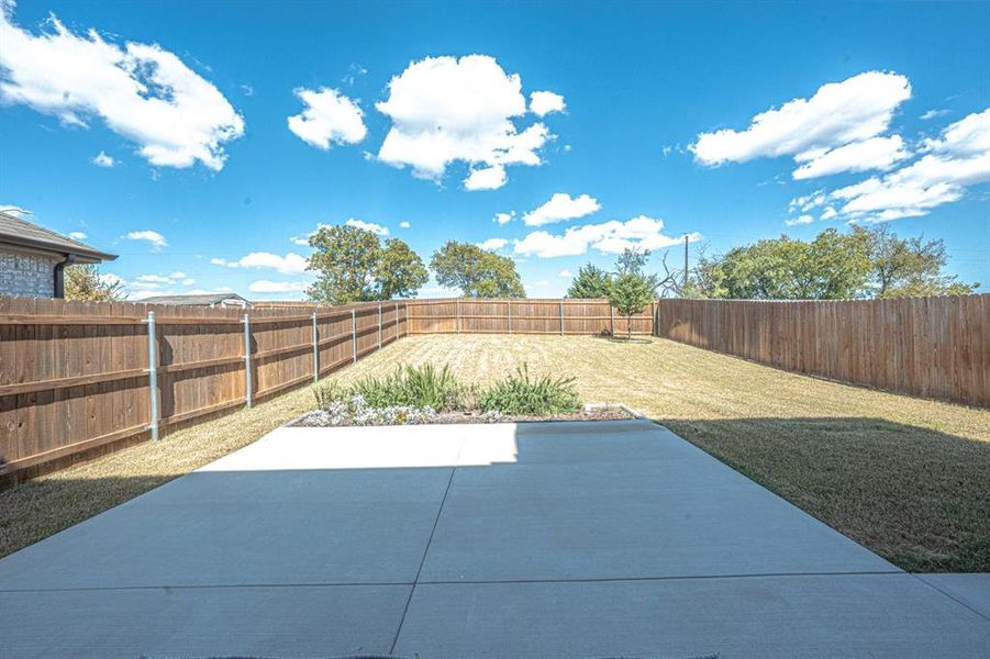 Fenced backyard with a patio area