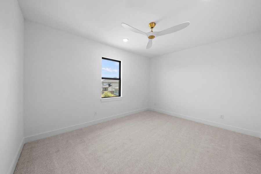 Bright secondary bedroom offering generous space and a peaceful atmosphere.