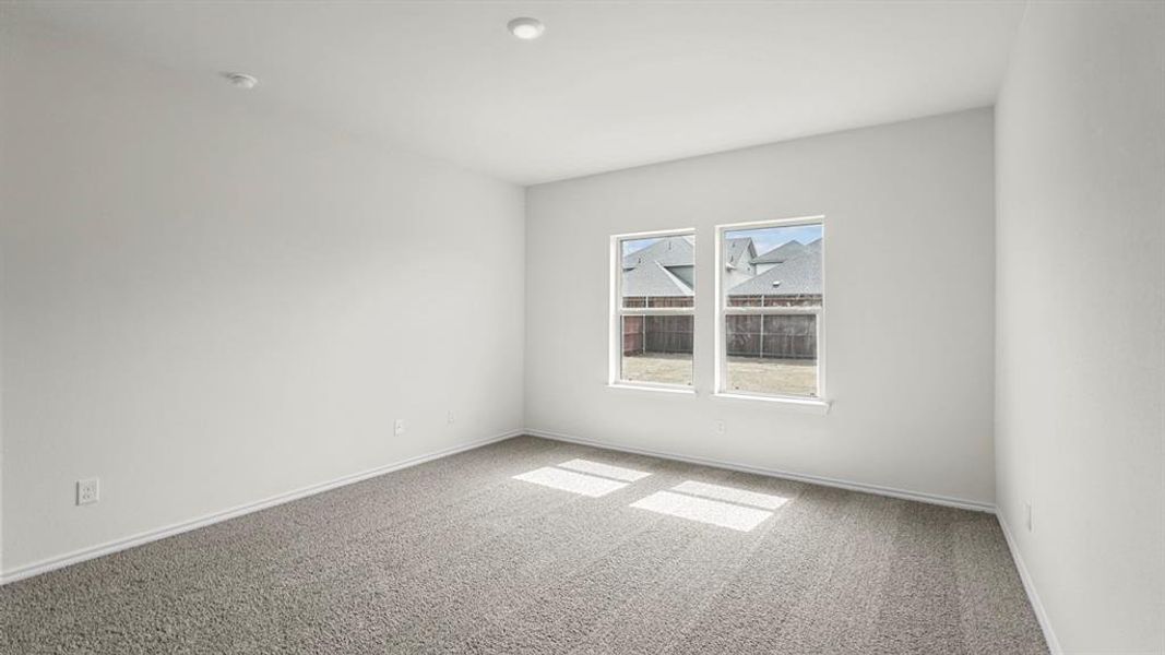 Spacious room featuring neutral carpeting, white walls, two recessed ceiling lights, and two large windows