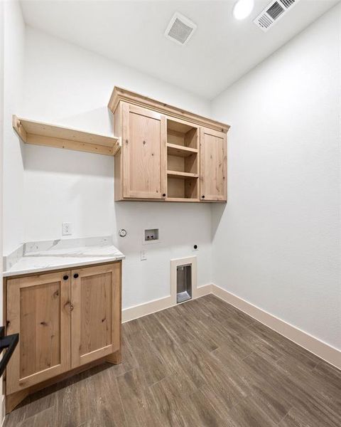 Laundry room featuring dark wood-type flooring, washer hookup, electric dryer hookup, cabinet space, and gas dryer hookup
