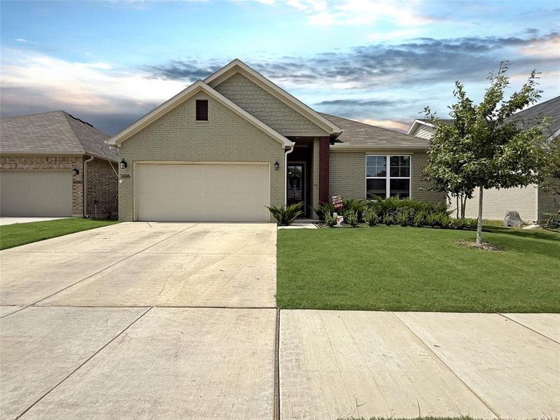 View of front of property with a garage, driveway, a lawn, a shingled roof, and brick siding View of front of property with a garage, driveway, a lawn, a shingled roof, and brick siding