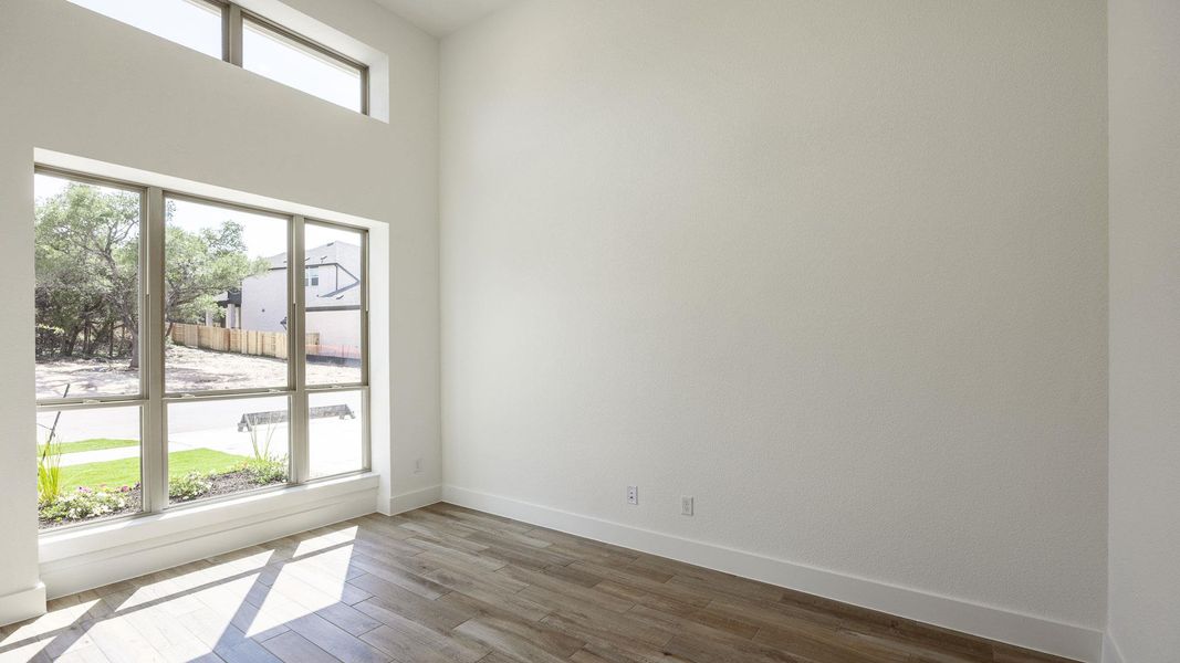 Empty room with dark wood-type flooring and baseboards Empty room with dark wood-type flooring and baseboards