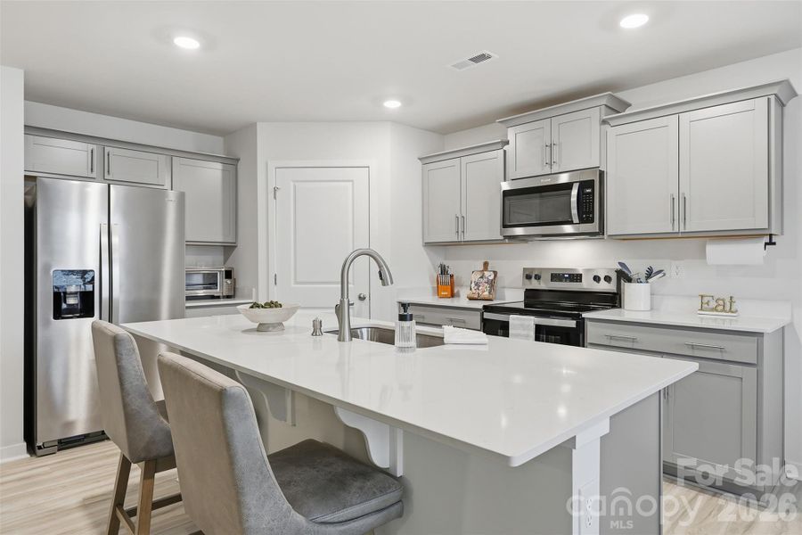 kitchen quartz counter tops, walk-in pantry with wooden shelves, fridge conveys