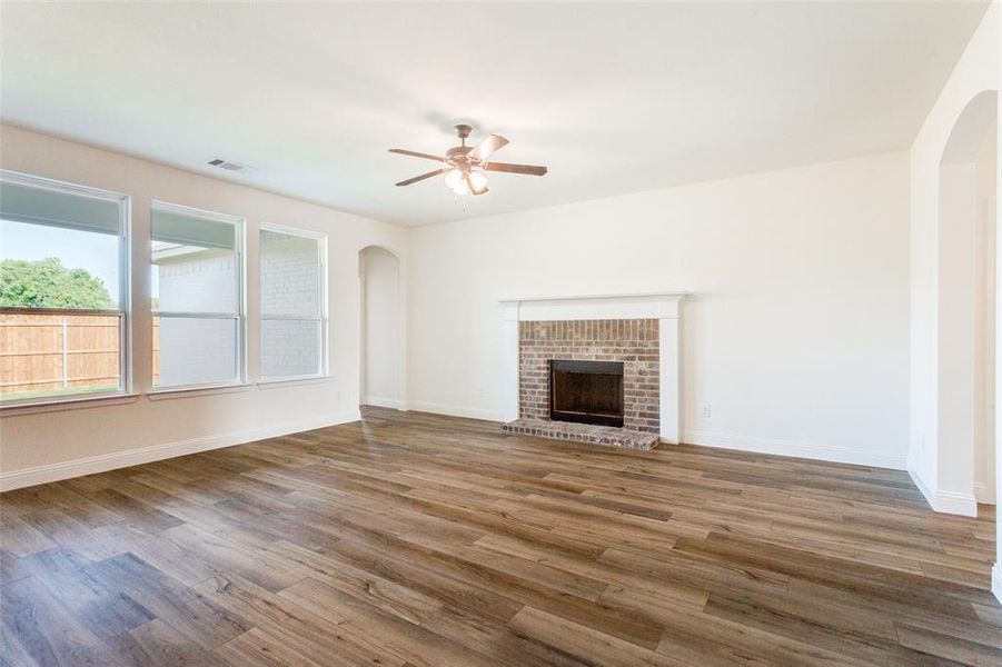 Unfurnished living room with a fireplace, ceiling fan, and hardwood / wood-style floors